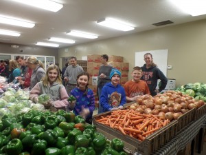 Volunteers help distribute fresh produce, meat and bread to the residents of Stringtown who are in need.